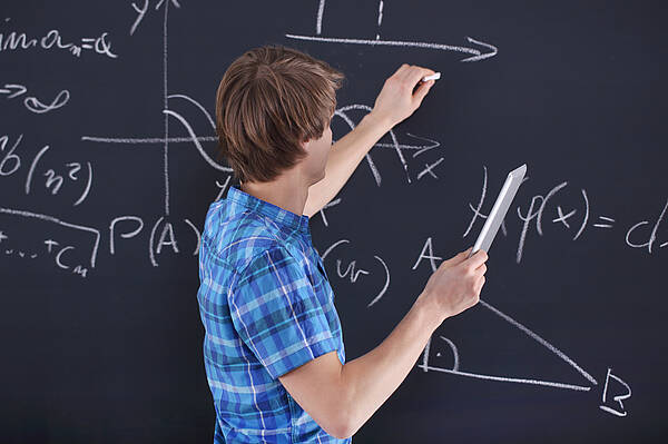 Lehrer an der Tafel mit mathematischen Formeln